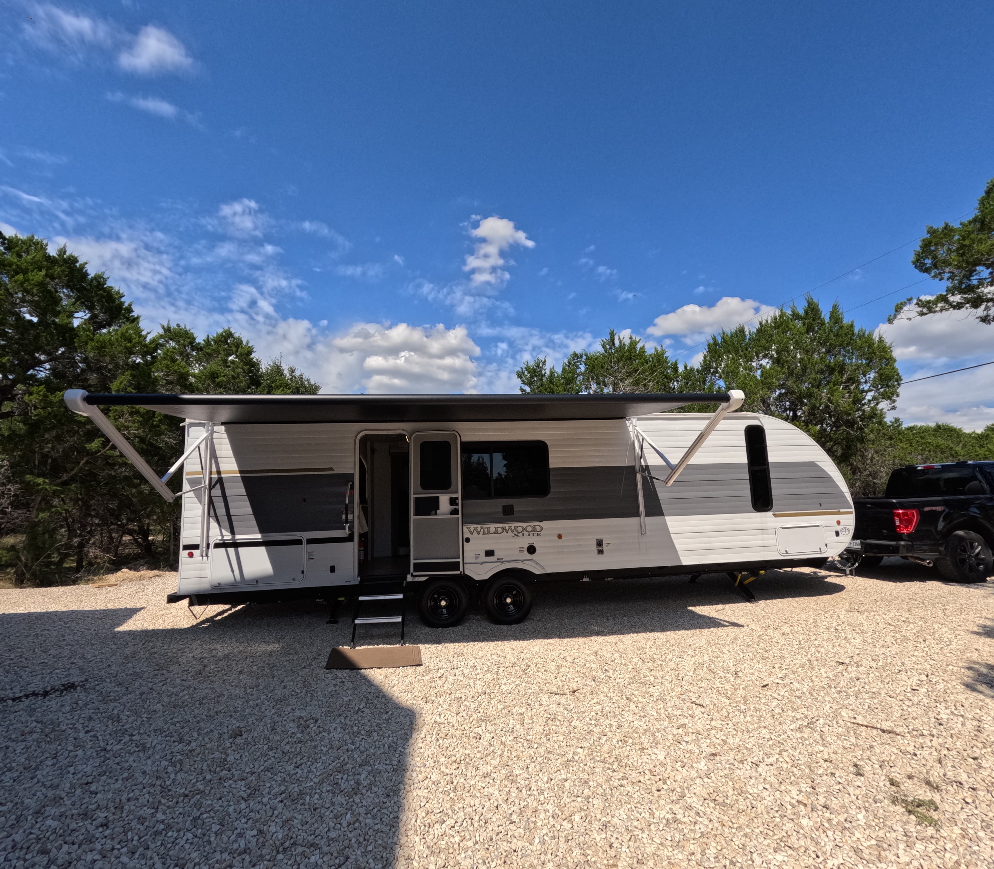 Trailer with awning extended, Hill Country backdrop